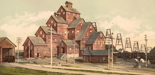 multi- sectional brownish-red wooden building with 4-5 levels of rooves,  plenty of windows to let light in.